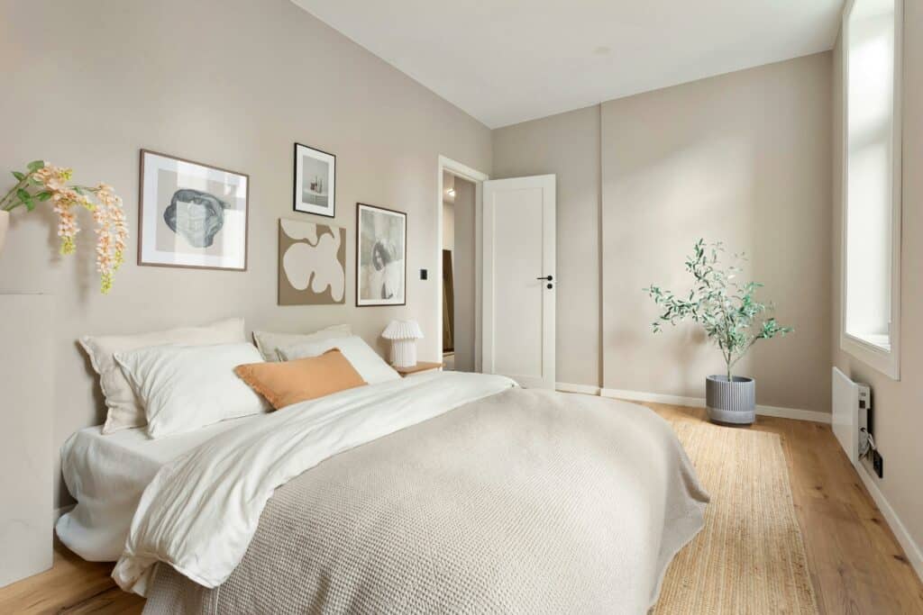 Bright minimalist bedroom showcasing modern design with neutral tones and stylish decor.